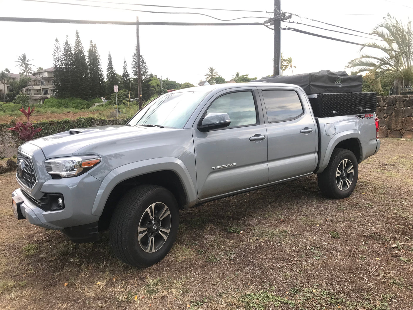 Grey Toyota Tacoma, rooftop tent & toolbox. An agile alternative to an rv rental for rugged exploration.