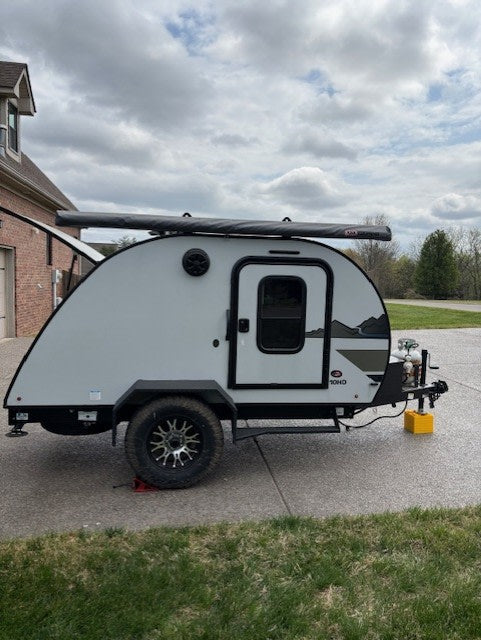 Stylish teardrop RV rental parked on a driveway