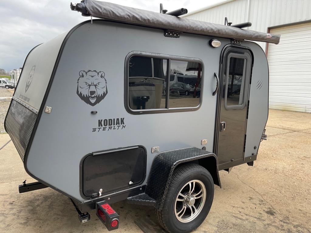 A rugged gray Kodiak Stealth compact travel trailer