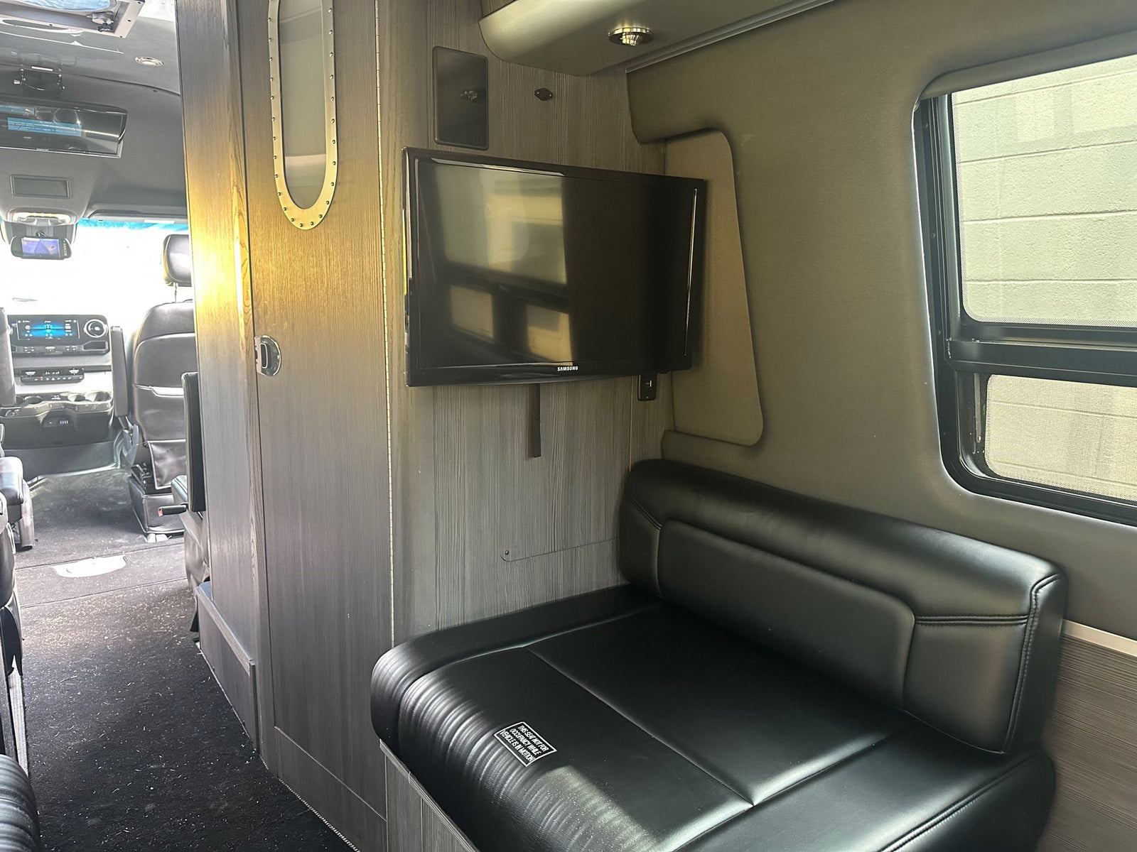 and wall-mounted dispensers. Brightly lit for convenience.|RV rental interior looking forward. Features include driver/passenger seats