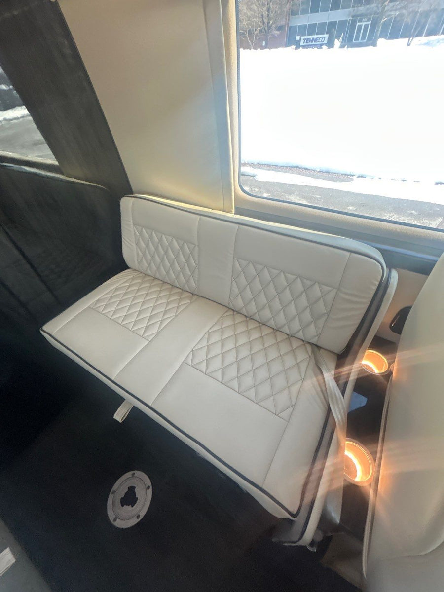 and stylish trim.|Premium RV rental interior: cream quilted captain's chairs
