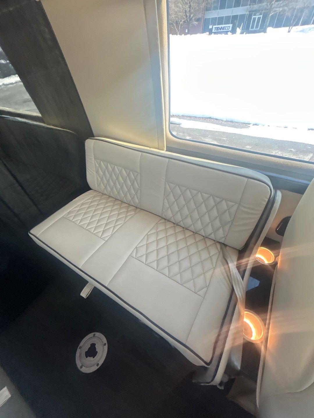 and stylish trim.|Premium RV rental interior: cream quilted captain's chairs