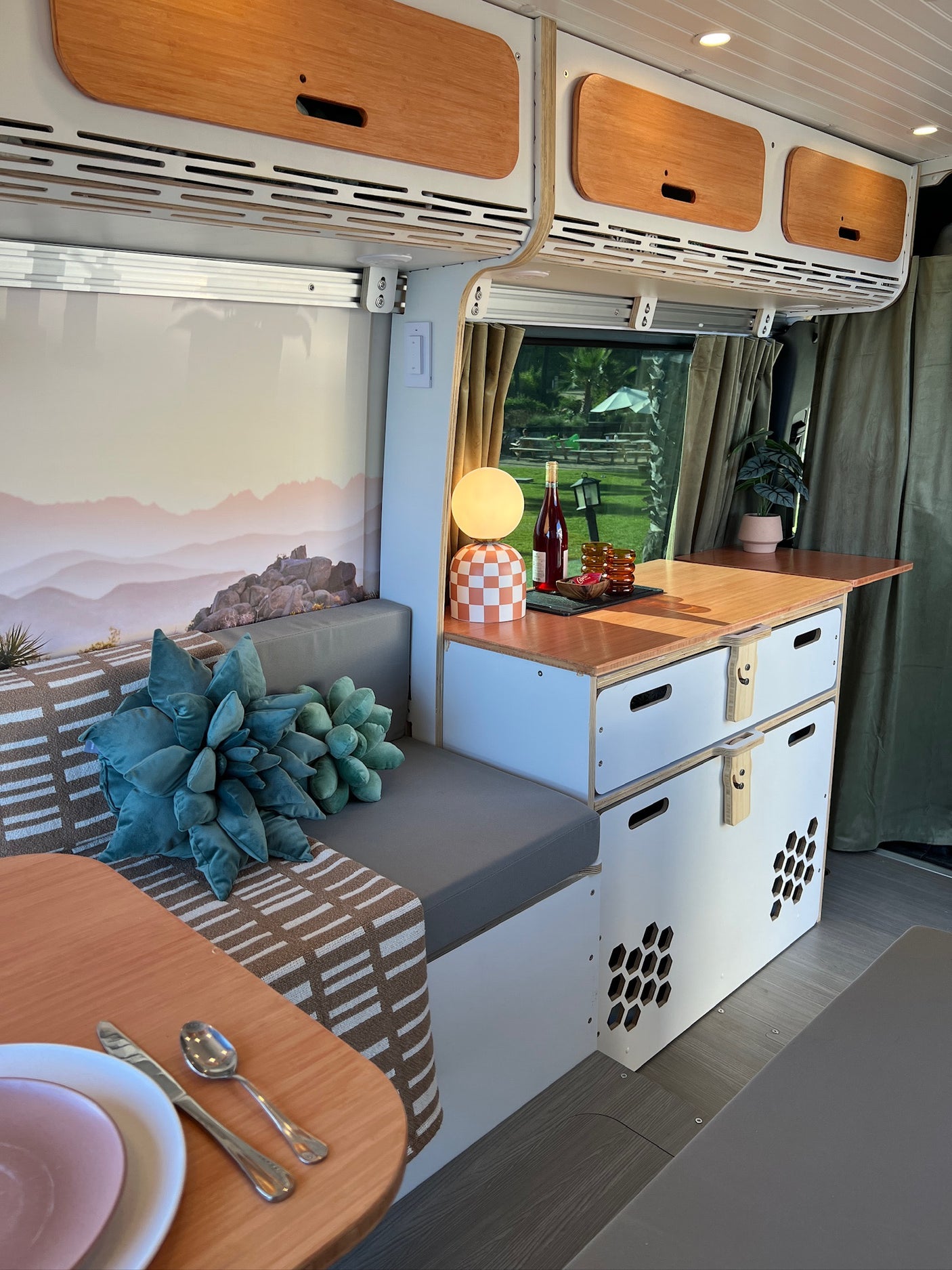 Step inside this cozy rv rental, showcasing a modern interior with kitchen, comfortable seating, and scenic window views.
