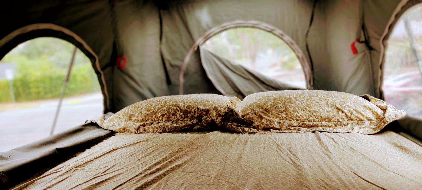 Cozy bed and pillows inside an RV rental tent, perfect for comfortable glamping adventures.
