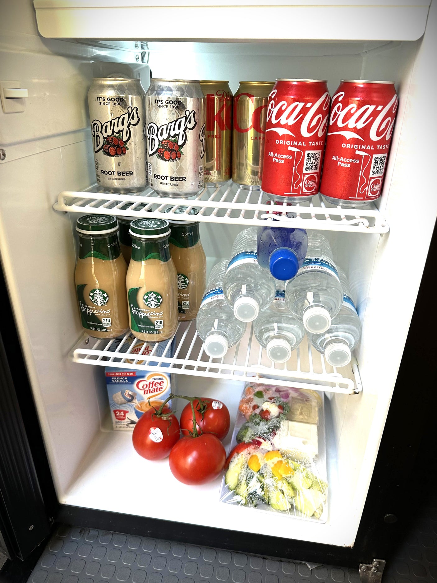 This rv rental mini-fridge is stocked with Barq's, Coke, Starbucks, water, Coffee-mate, fresh tomatoes, and pre-cut veggies.