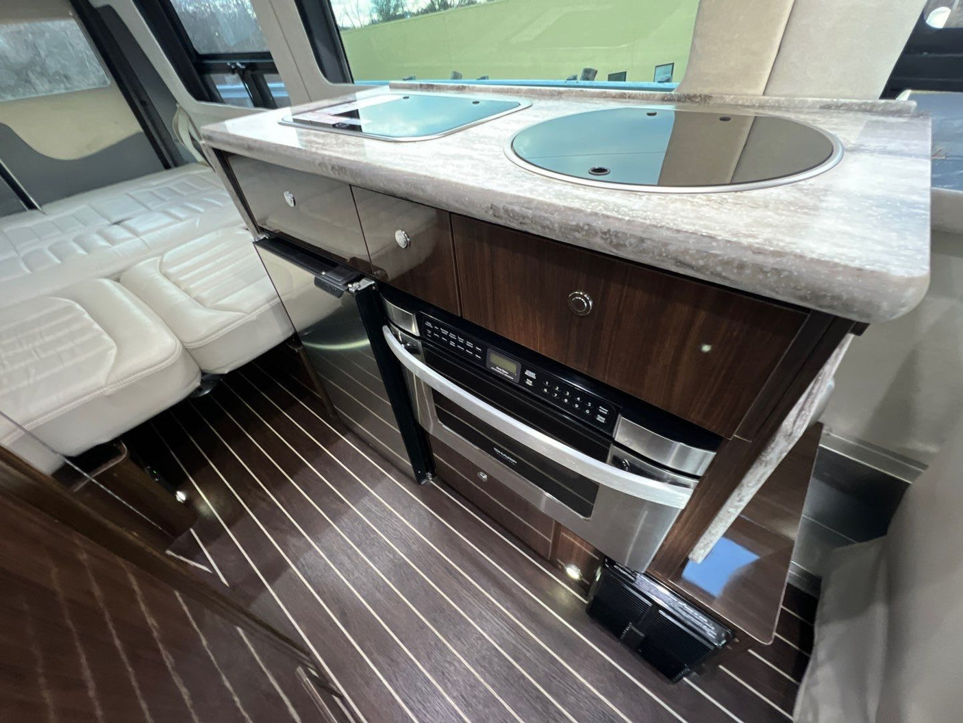 side view. This sleek Class B motorhome has tinted windows and utility ports.|Compact RV rental bathroom with white toilet