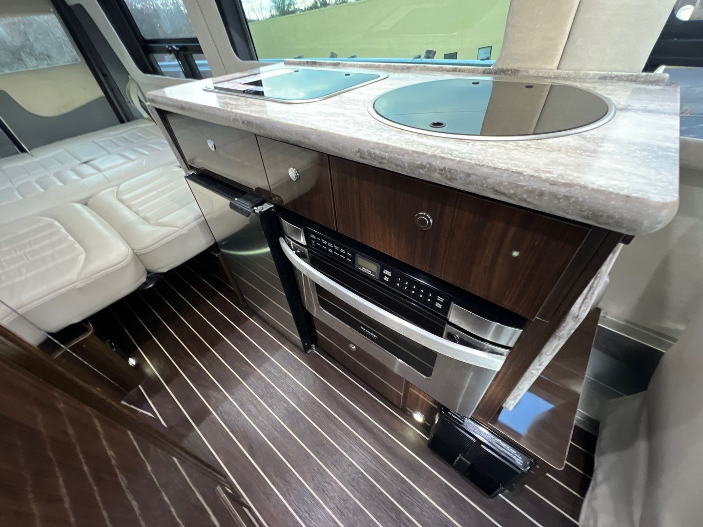 side view. This sleek Class B motorhome has tinted windows and utility ports.|Compact RV rental bathroom with white toilet