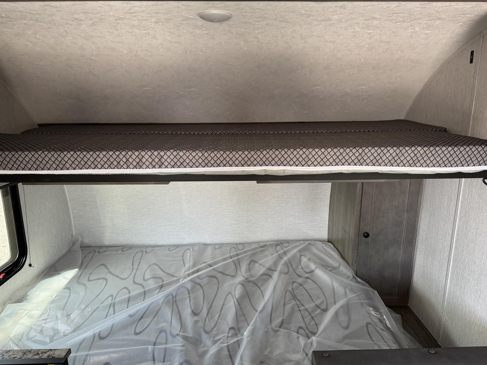 an ideal RV rental for outdoor adventures and camping trips.|RV rental: Upper bunk bed with patterned mattress