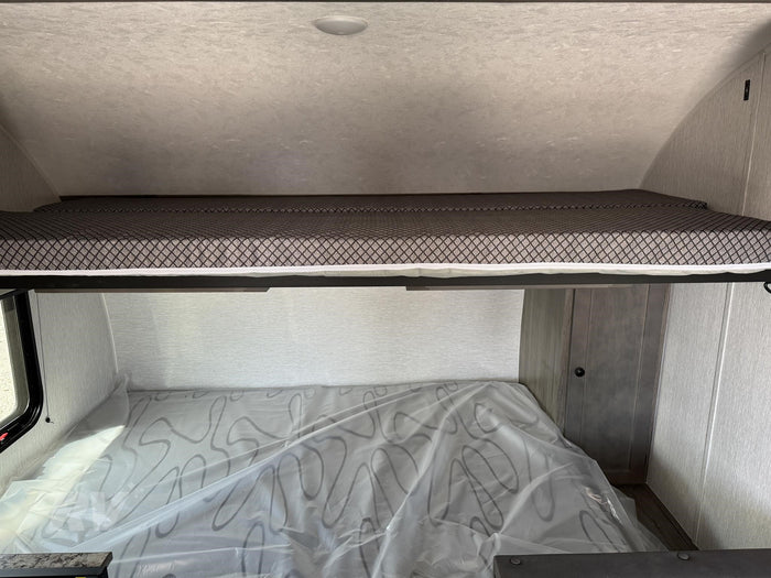 an ideal RV rental for outdoor adventures and camping trips.|RV rental: Upper bunk bed with patterned mattress