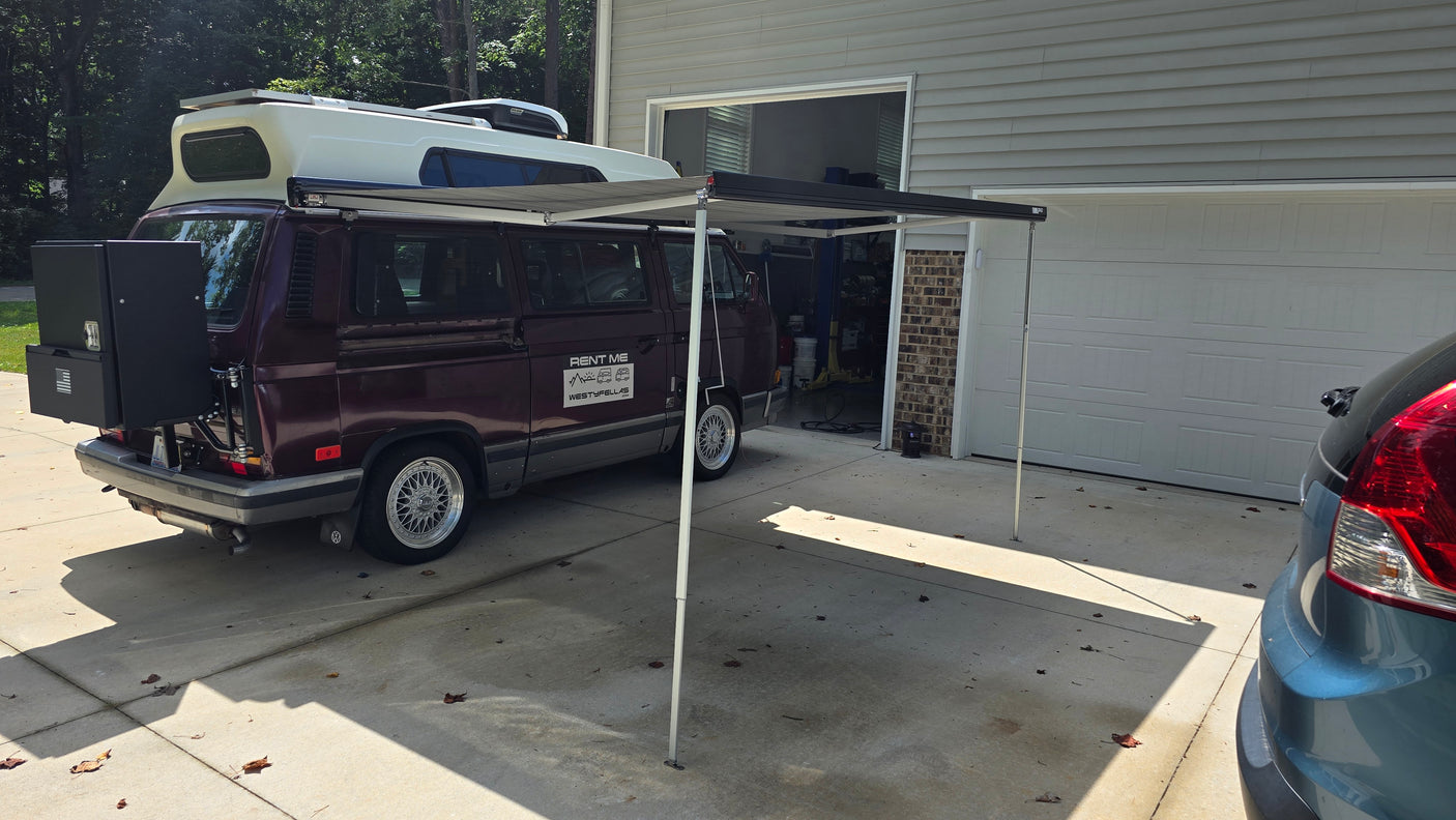 Maroon VW camper van with awning extended, ready for adventure. Available for rv rental from WestyFellas.com.