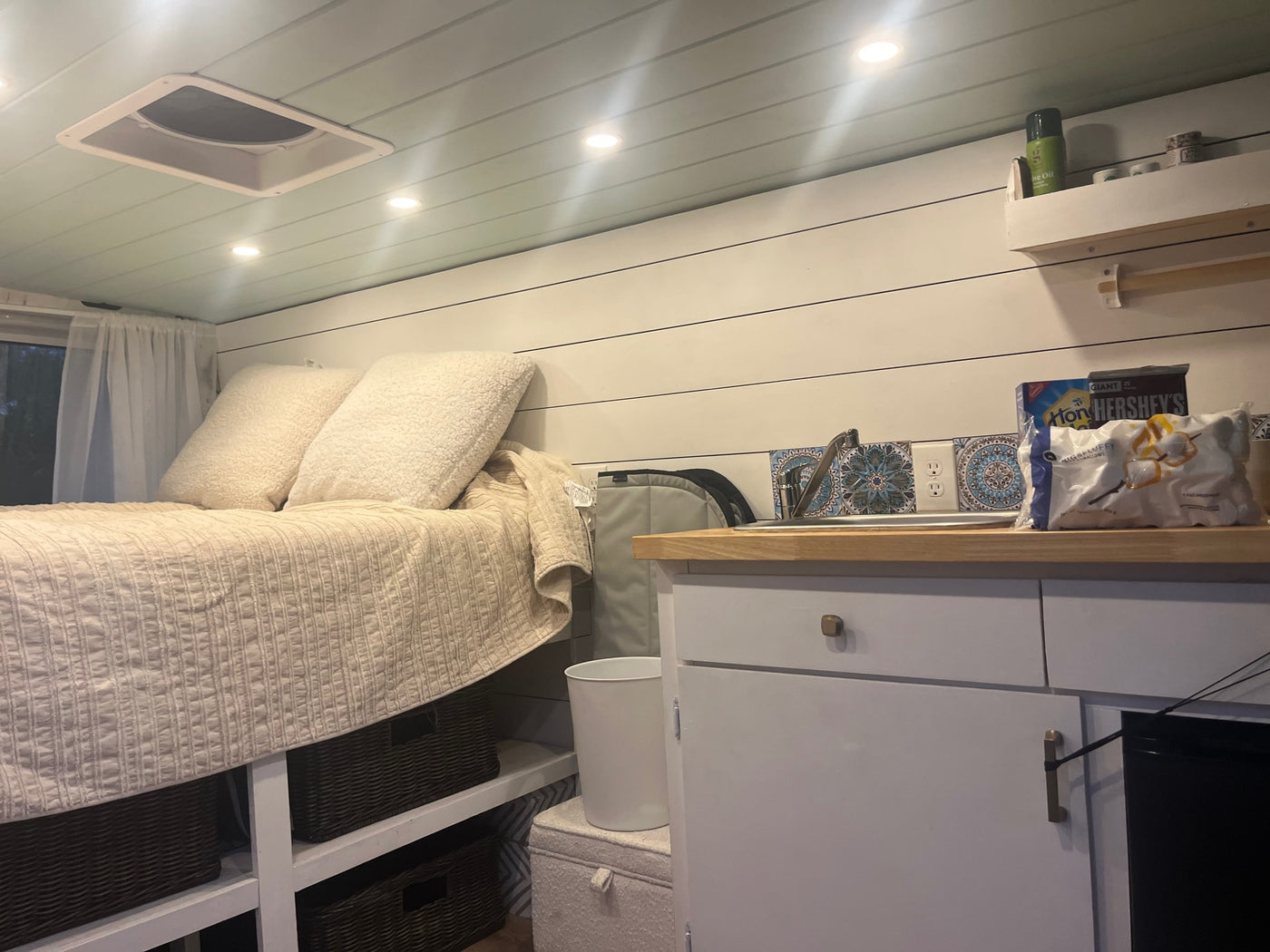 Explore this cozy RV rental interior with a comfortable bed, compact kitchen, and organized storage solutions. — photo 8