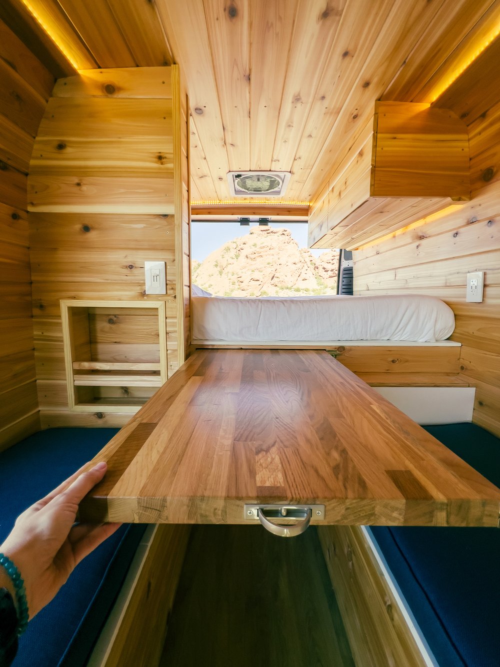 & scenic desert views from open doors.|White camper van RV rental