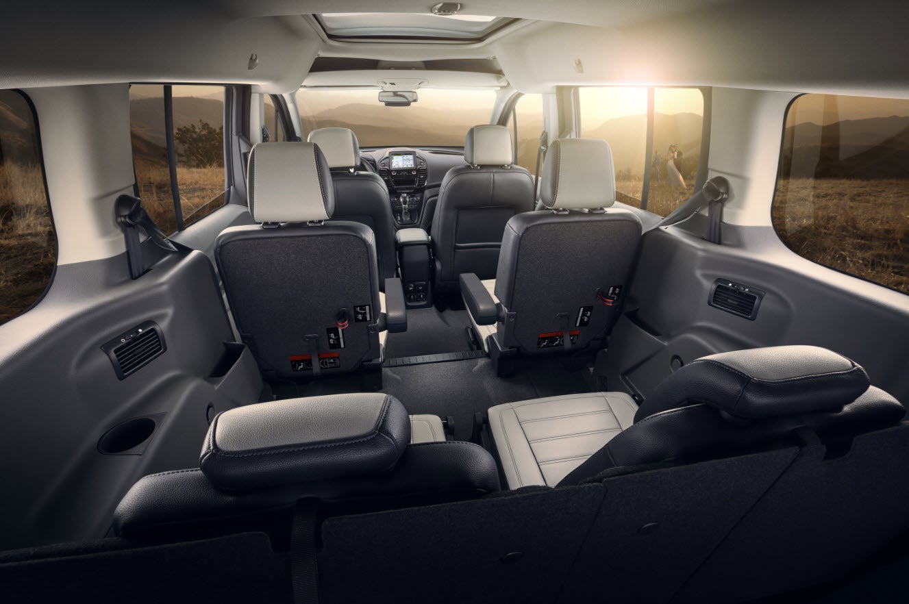 Spacious multi-passenger vehicle interior, viewed from the back. Shows three rows of comfortable seating, ideal for your RV rental.