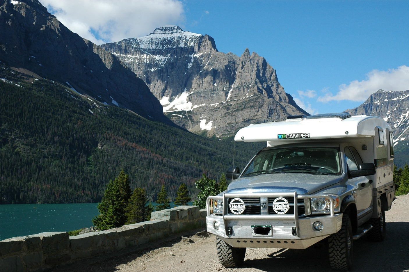 An XP Camper truck by a vibrant mountain lake