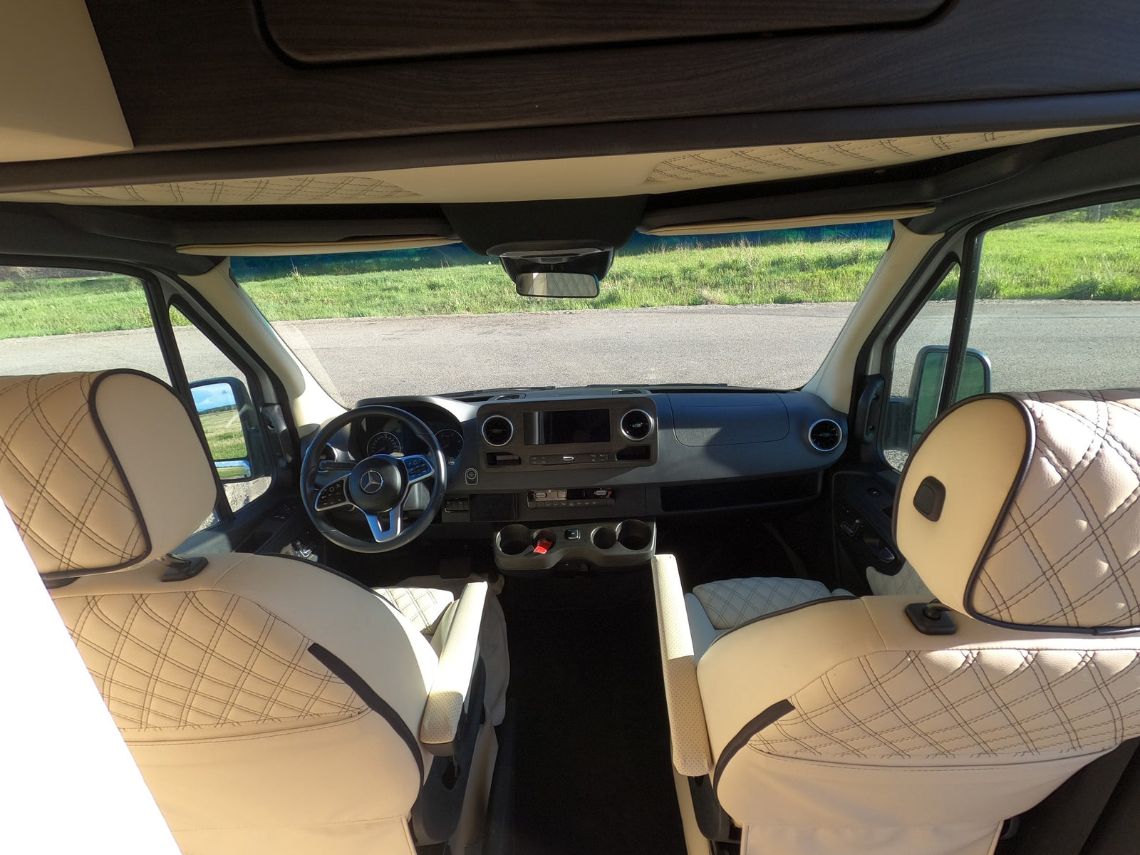 Interior of an rv rental cabin, showcasing luxurious quilted seats, a modern dashboard, and steering wheel.
