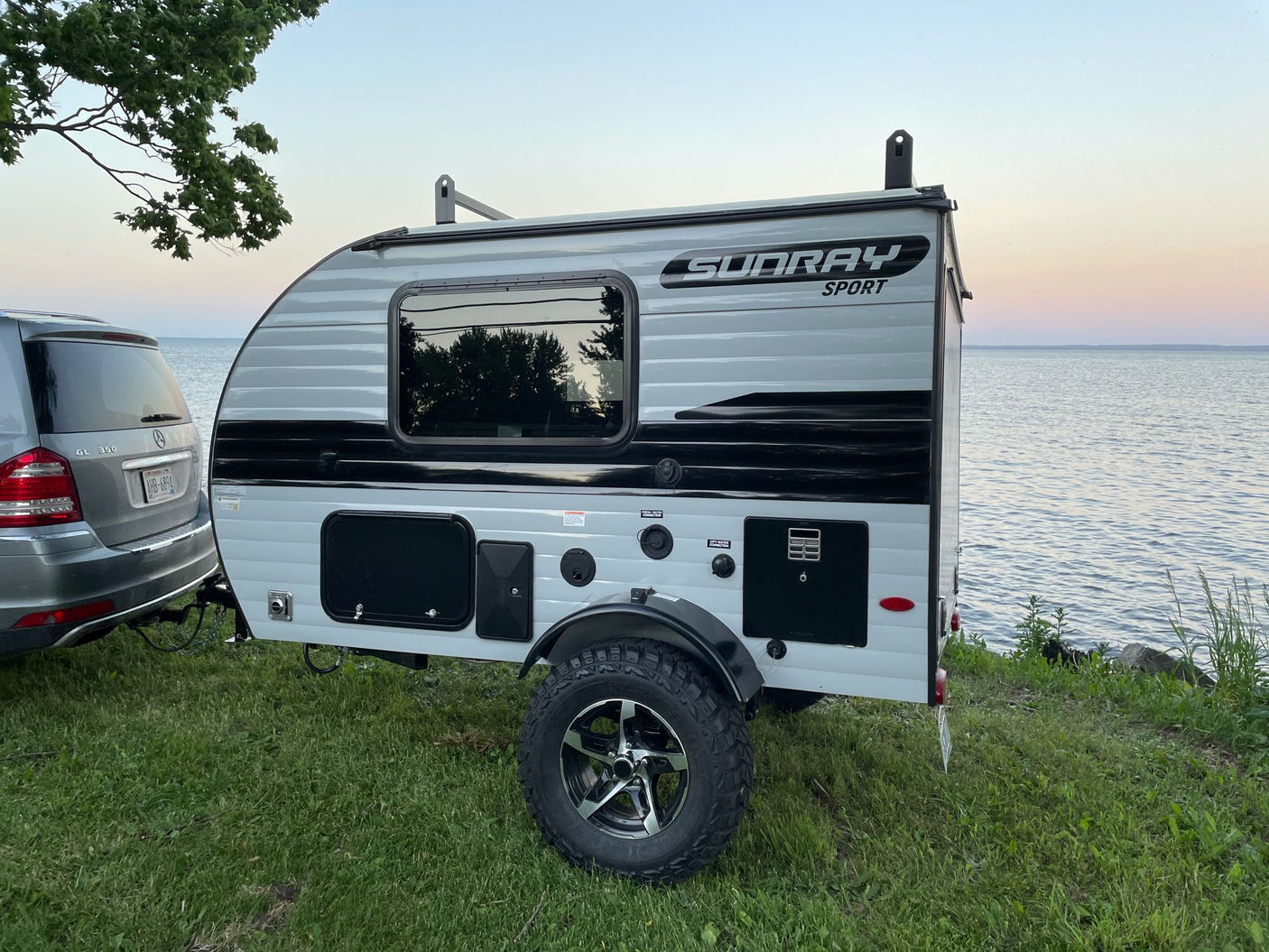 Compact Sundray Sport RV rental parked by a tranquil lake at dusk