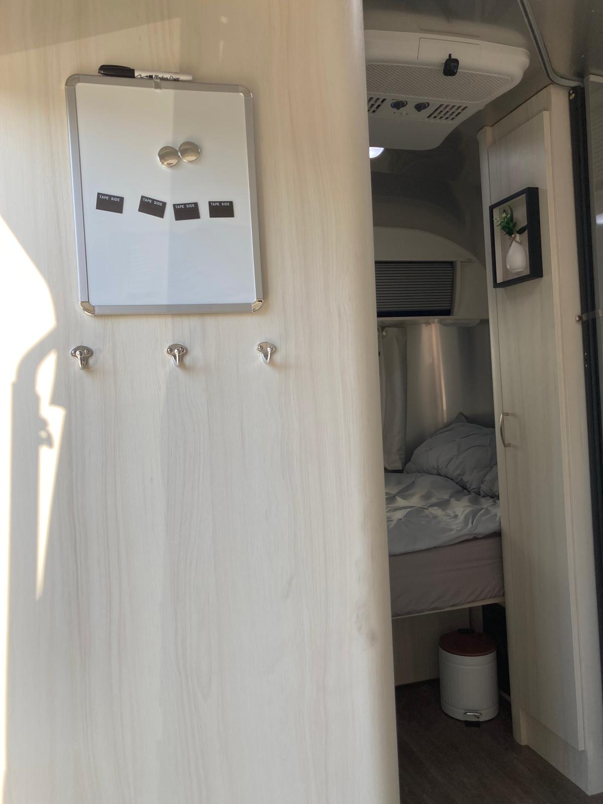 plus comfy dinette seating.|Two propane tanks with a regulator visible in a metal RV rental storage compartment.|Bright RV rental bathroom with a compact shower — photo 14