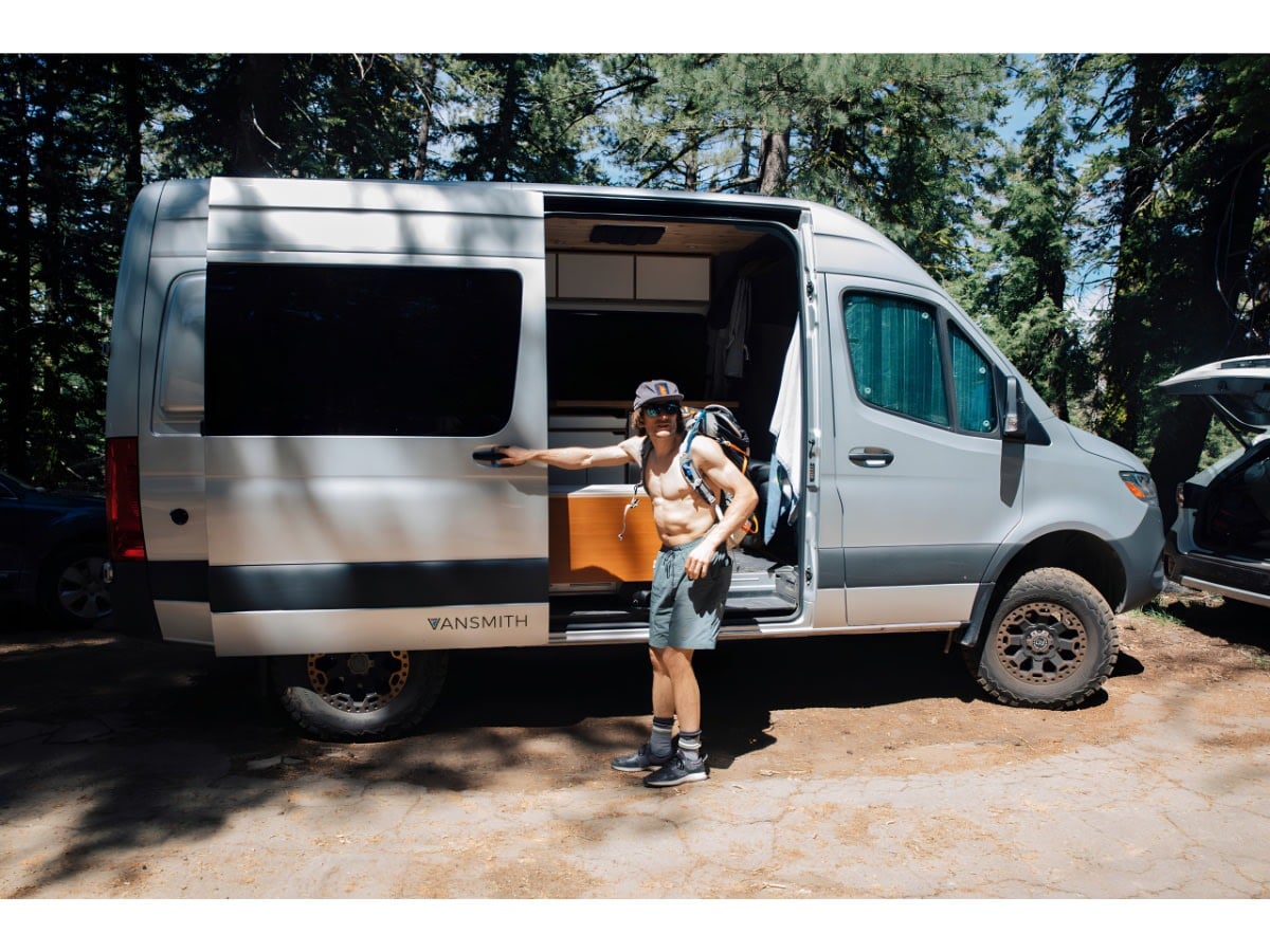 Enjoy an RV rental adventure! A man smiles next to his open Vansmith camper van — photo 1