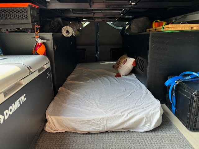 Inside an **rv rental**: a compact sleeping area with Dometic fridge, ready for adventure and travel. Perfect for van life camping.