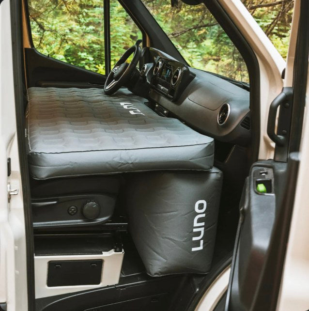 This RV rental shows a comfy Luno air mattress set up as a bed in the front van cabin for easy camping.