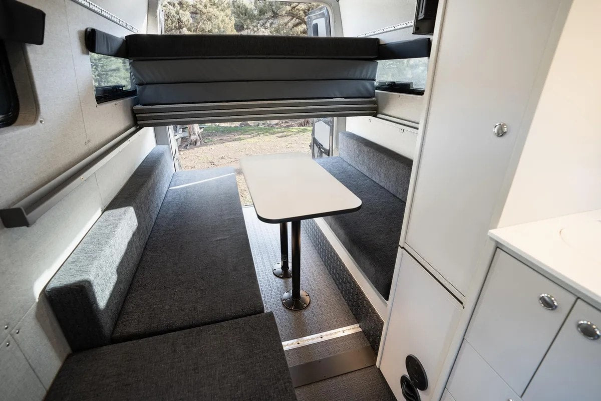 and upper cabinets. Ready for your next road trip.|RV rental campervan interior: dining area with benches — photo 6