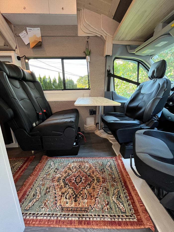 and comfortable passenger seating.|RV rental: View inside a custom camper van with bunk bed