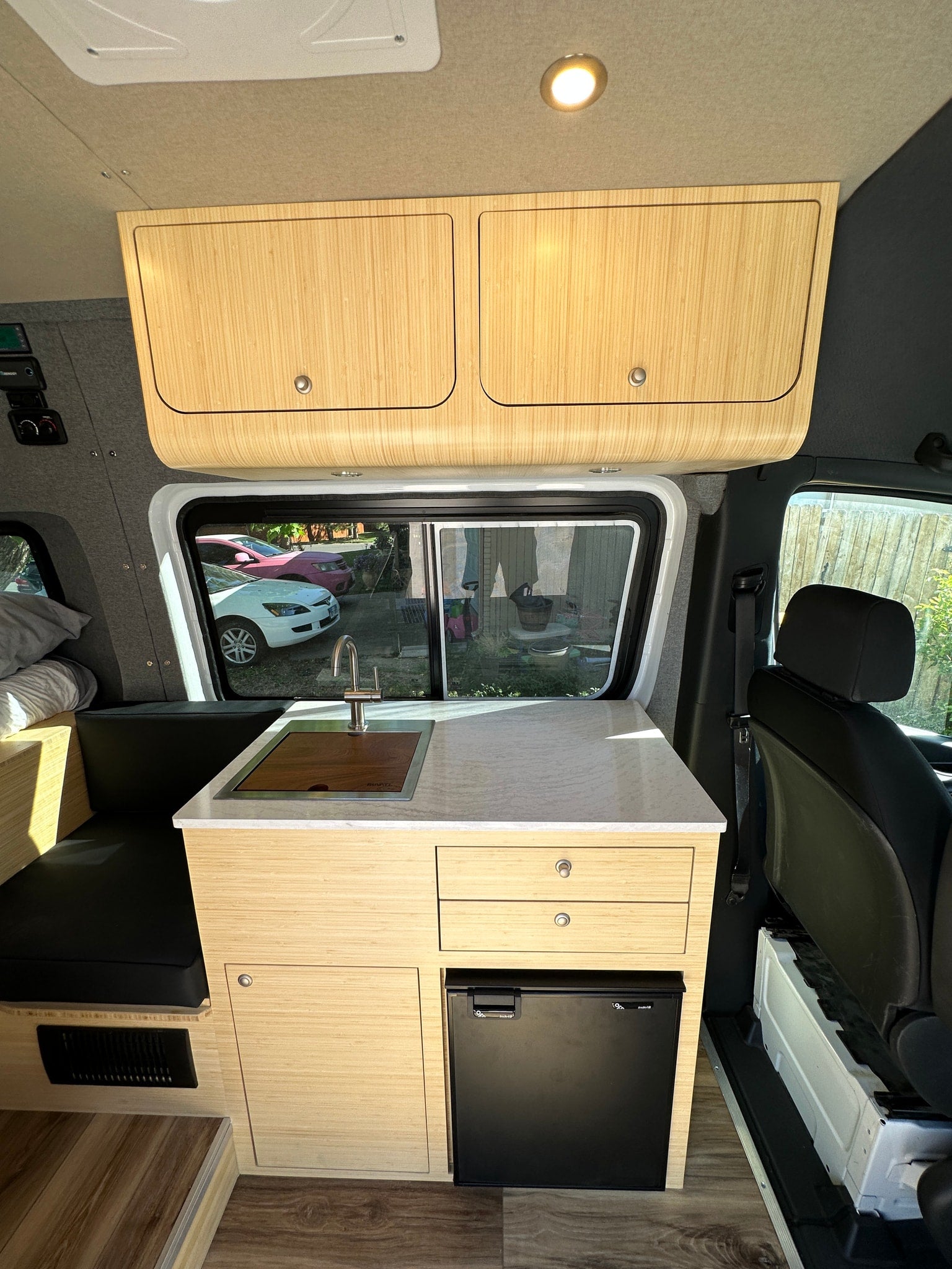 and dinette make for a functional camper van.|Interior of a modern RV rental camper van with a bed