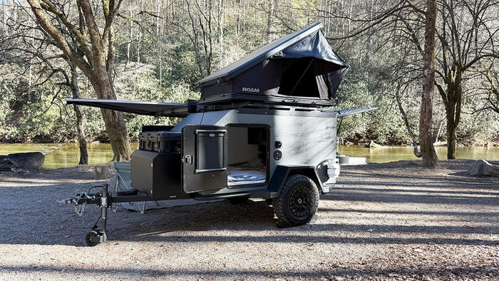 parked by a river – ideal for an rv rental.|Compact Cedar Ridge Campers rv rental with a deployed ROAM rooftop tent by a serene river