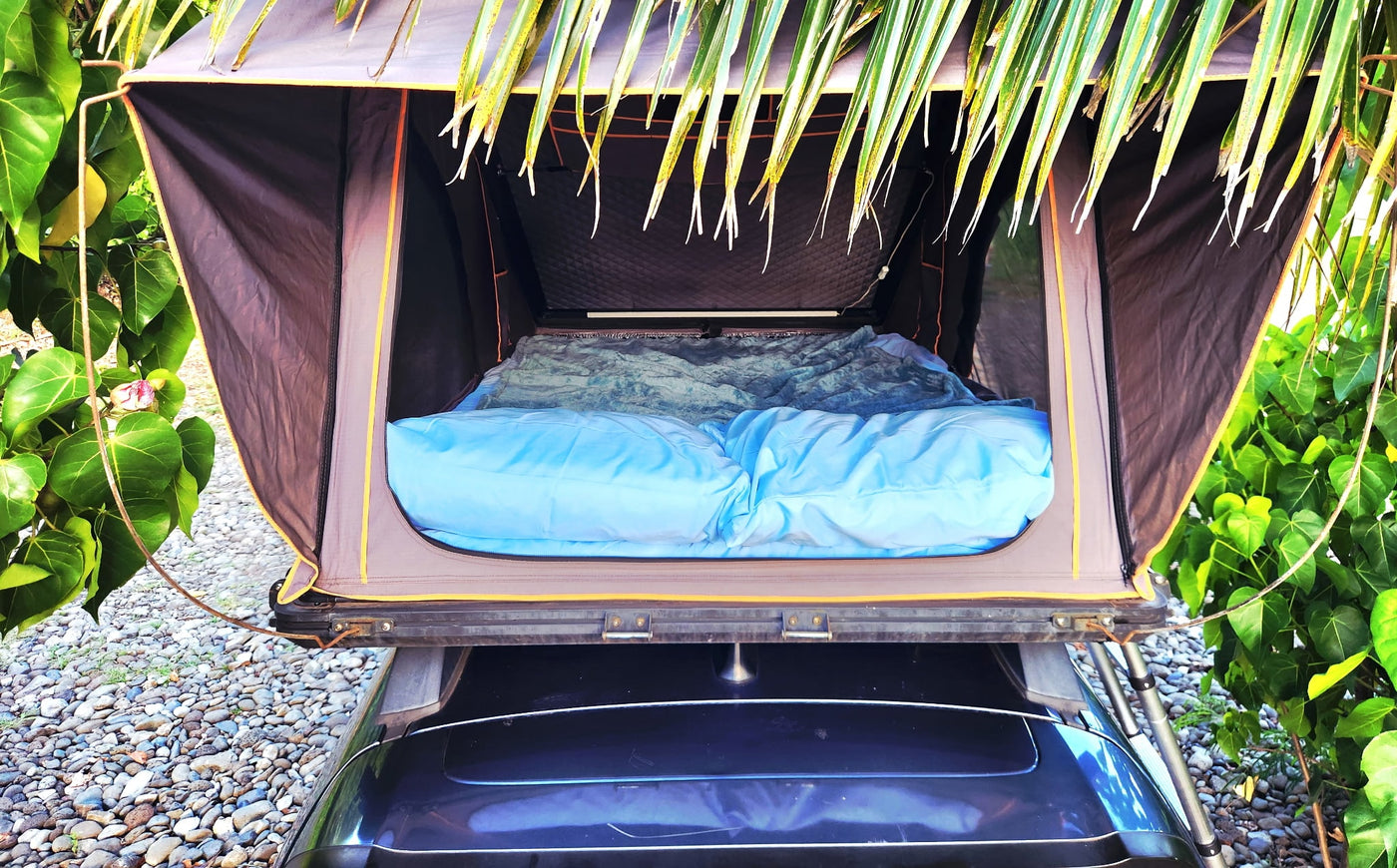 featuring an open rooftop tent set for coastal camping by the sunny ocean.|Packing for an RV rental trip! A woman organizes gear in her SUV with a rooftop tent — photo 8