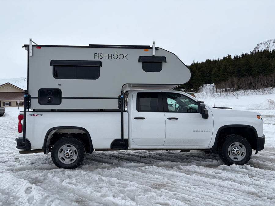 White Chevrolet 2500 HD 4x4 truck with a "FISHHOOK" RV camper