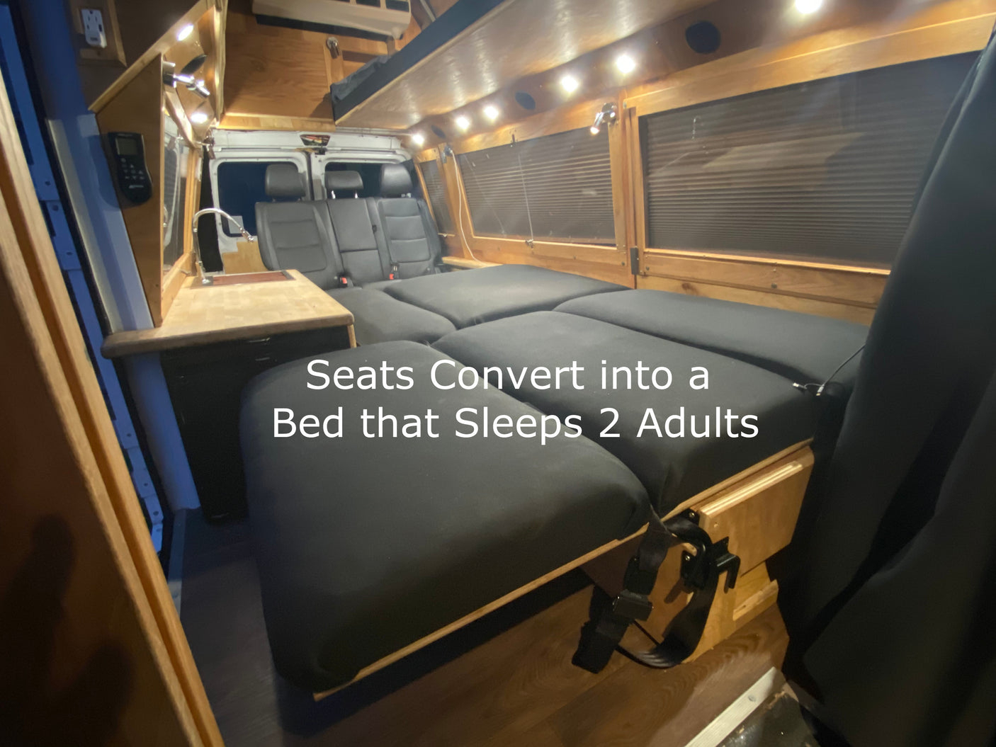 This cozy RV rental features a van interior with seats converting into a spacious bed for 2 adults, complete with a kitchenette.