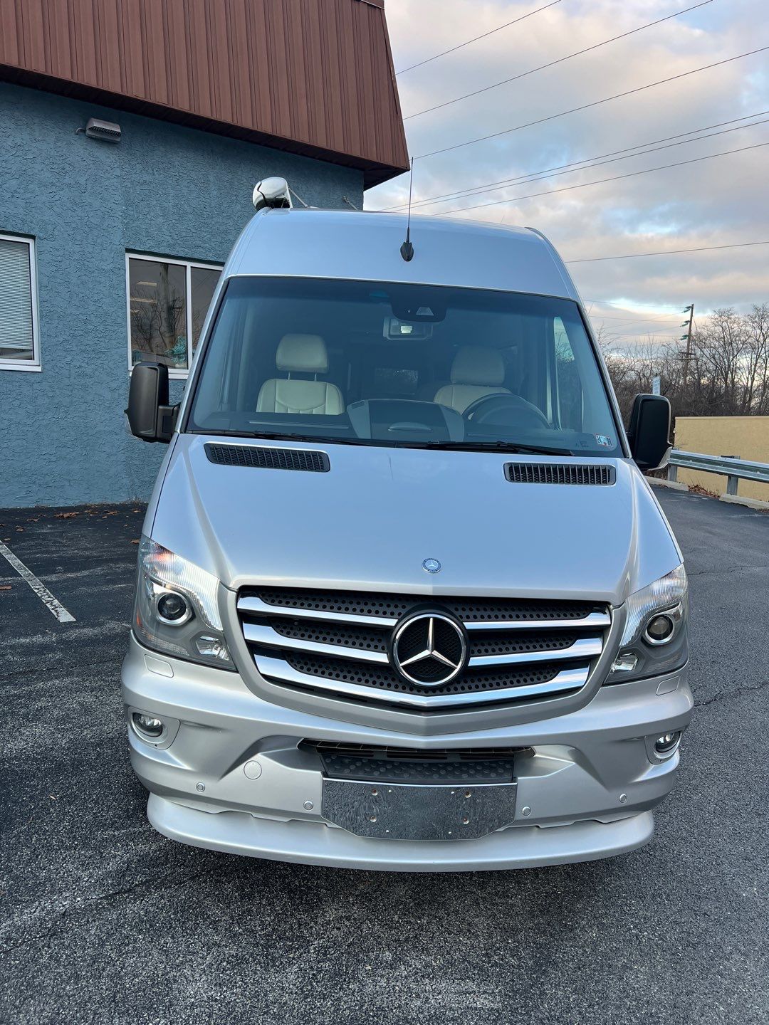 Silver Mercedes-Benz Sprinter van, front view, parked for an RV rental. Perfect for your next adventure.