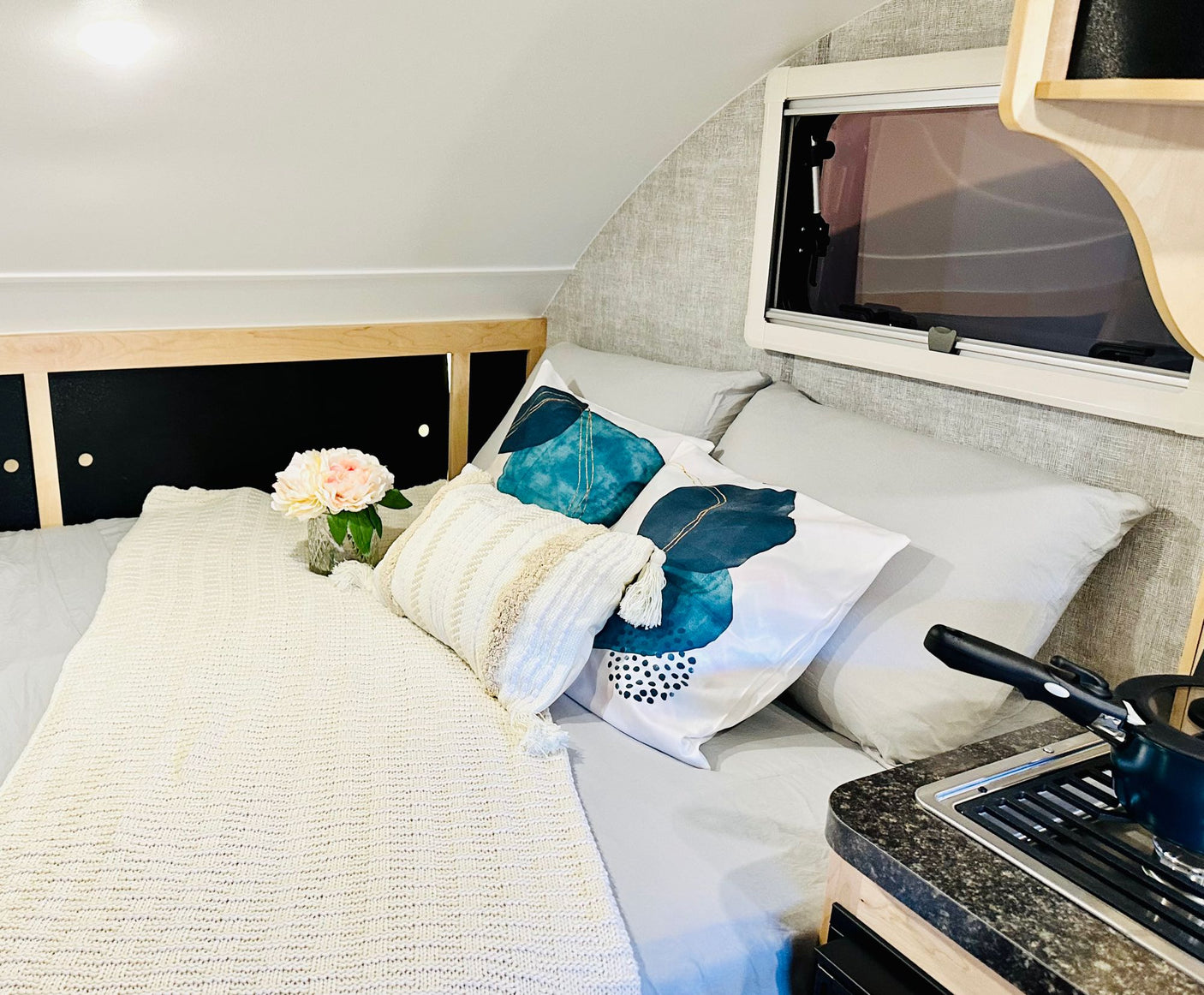 parked on grass. Perfect RV rental trip!|This compact RV rental features a cozy dinette with teal place settings