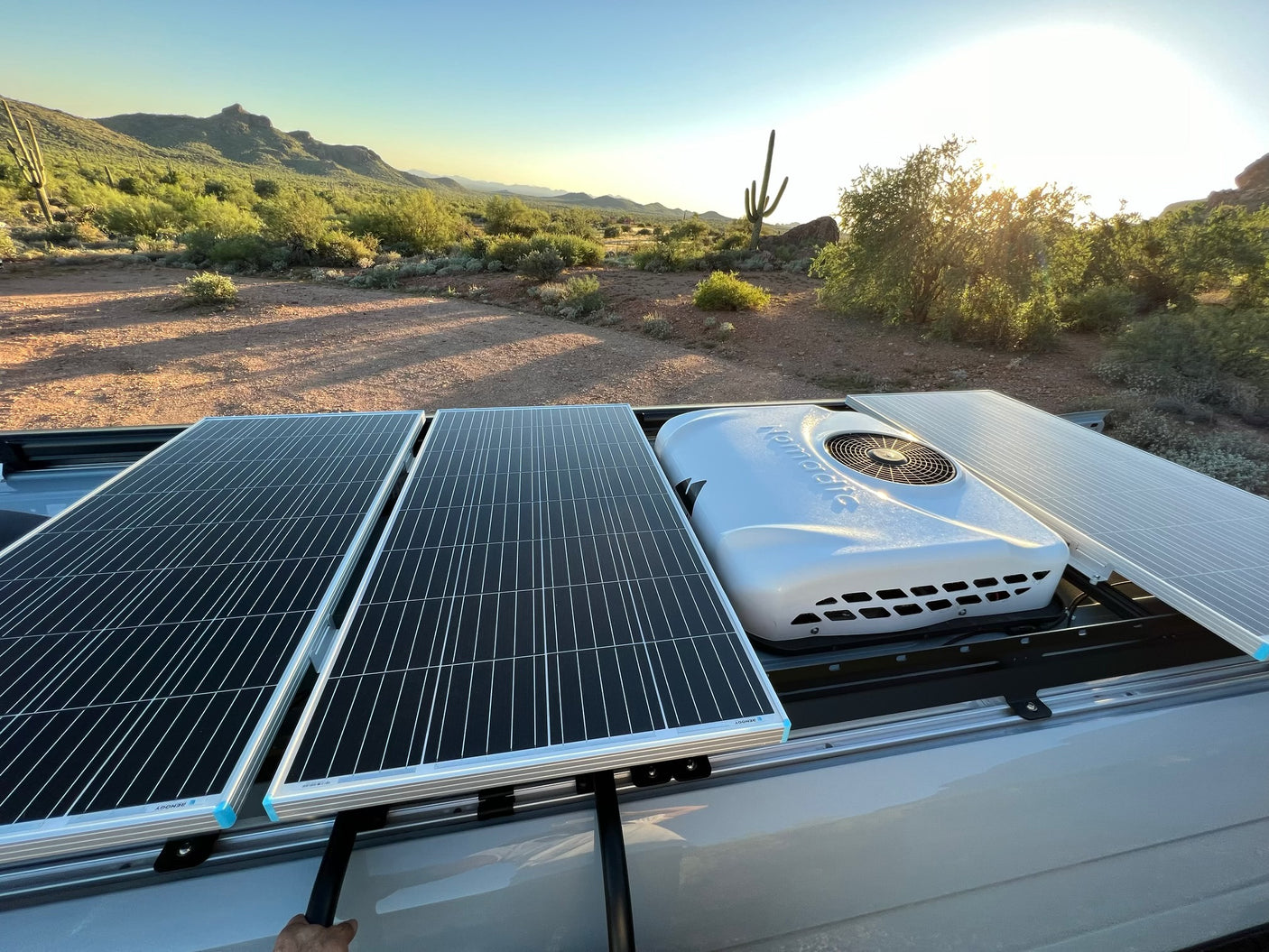 An rv rental with rooftop solar panels & AC unit in a sunny desert landscape. Perfect for off-grid adventures.