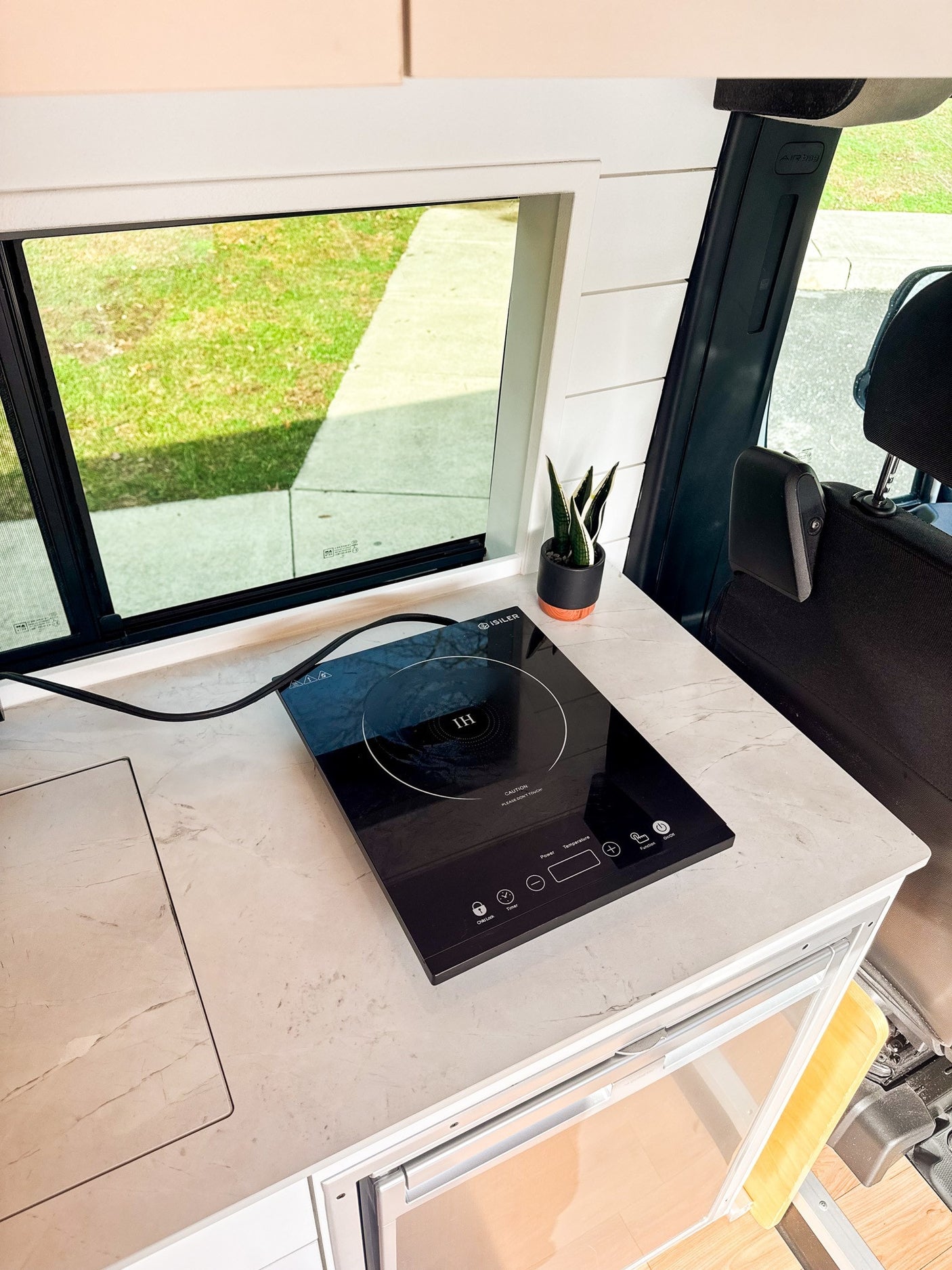 and window nook.|Modern RV rental kitchen with black faucet