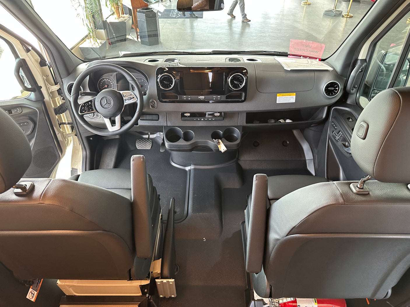 A view from behind the front seats of a Mercedes-Benz van, showing the spacious cockpit and dashboard, great for RV rental.