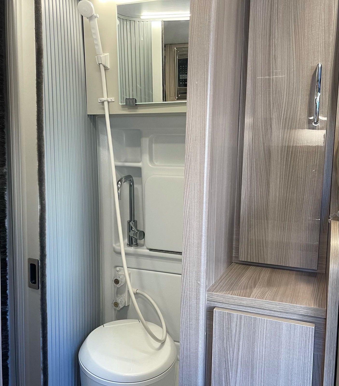 Tour this RV rental's clever compact wet bath, featuring a shower, toilet, and sink, plus built-in storage.