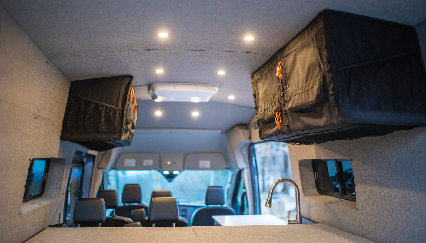 and window. Ideal for comfortable travel and adventure.|Modern stainless steel sink and faucet in a compact RV rental kitchen.|RV rental interior: a compact kitchen with wood cabinets