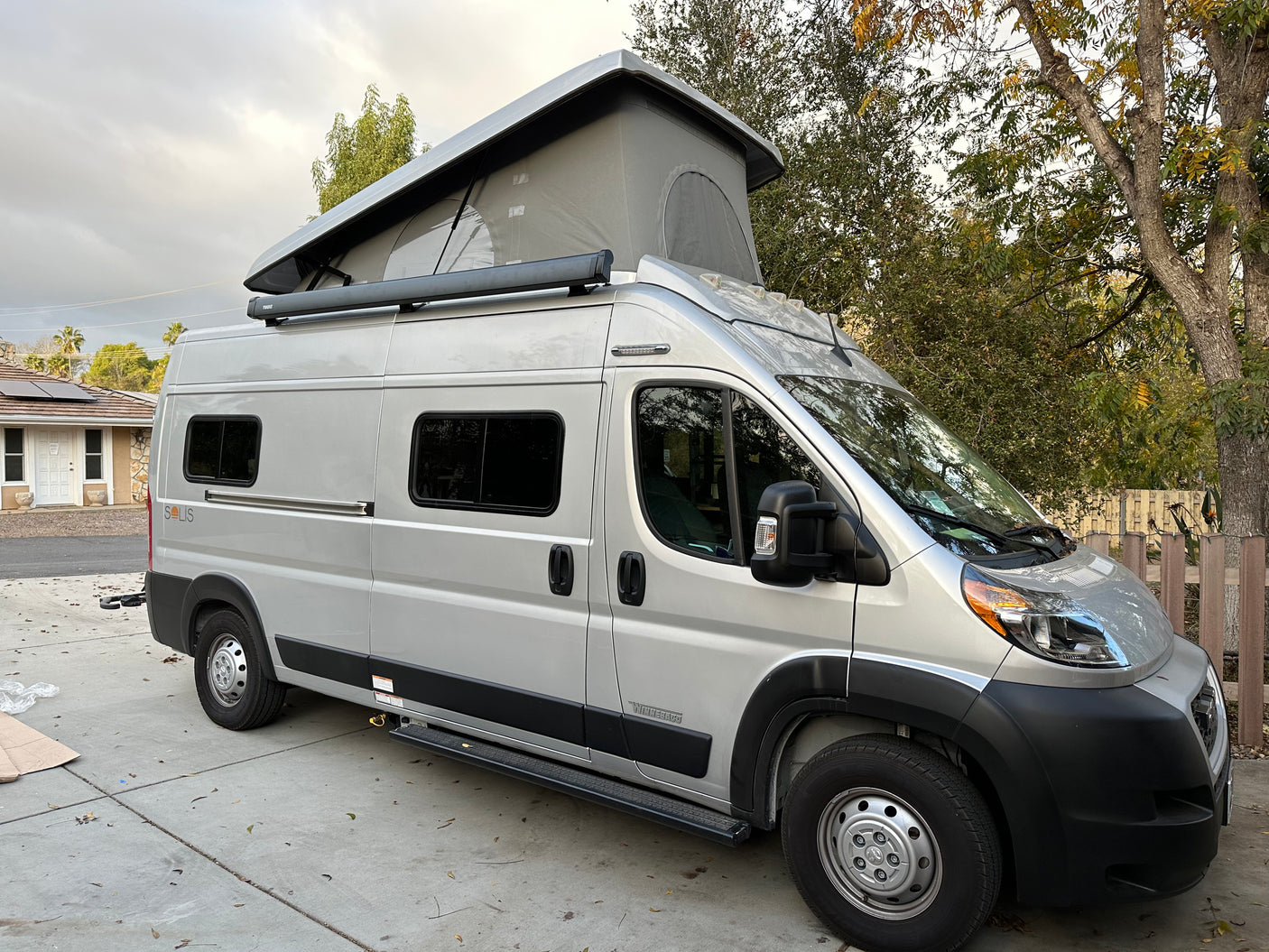 Silver Winnebago Solis camper van, an excellent rv rental option, featuring a pop-top roof and Thule awning.