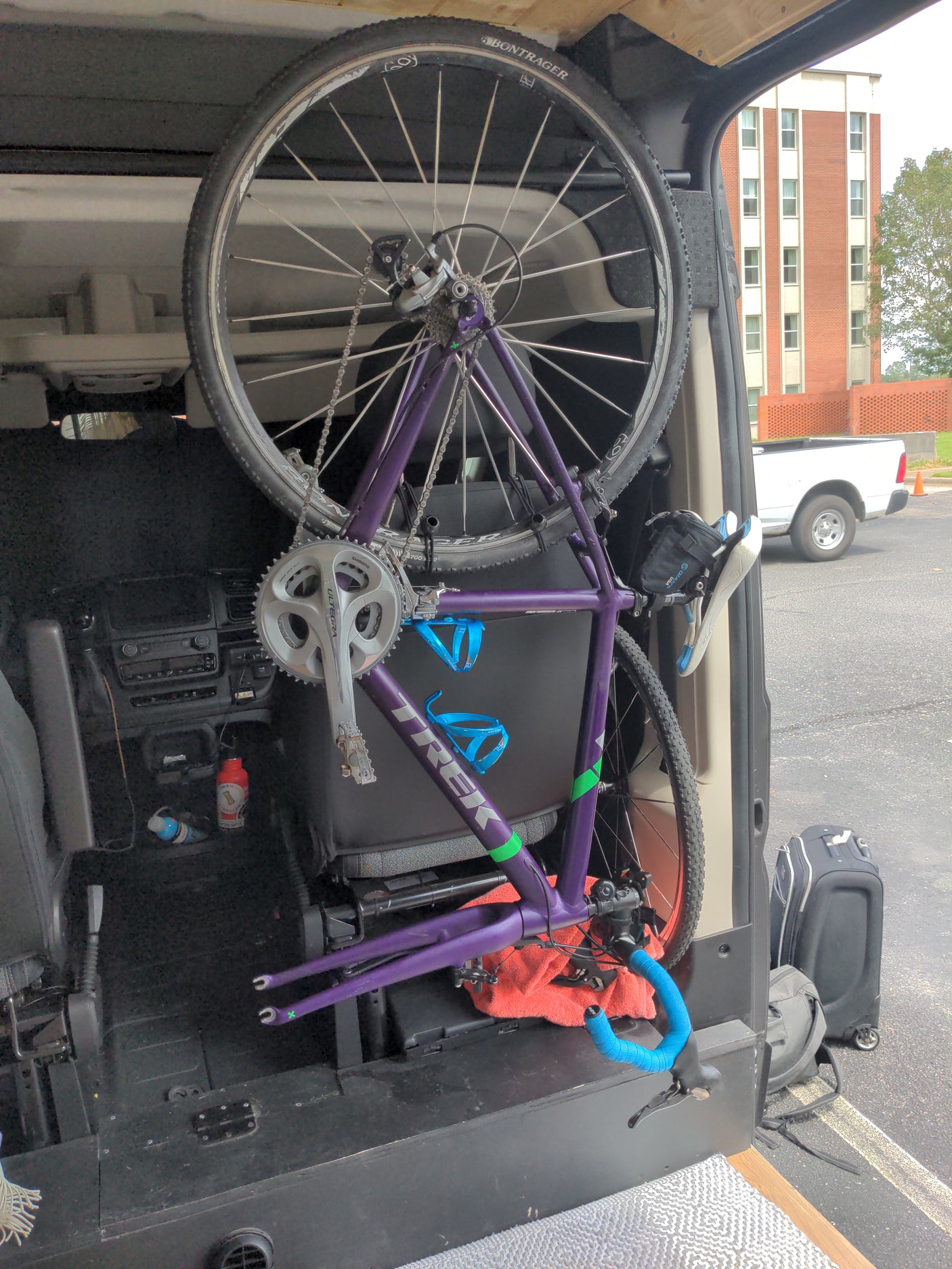 Purple Trek bicycle packed inside an rv rental, with front wheel removed for efficient storage. Perfect for a cycling adventure.