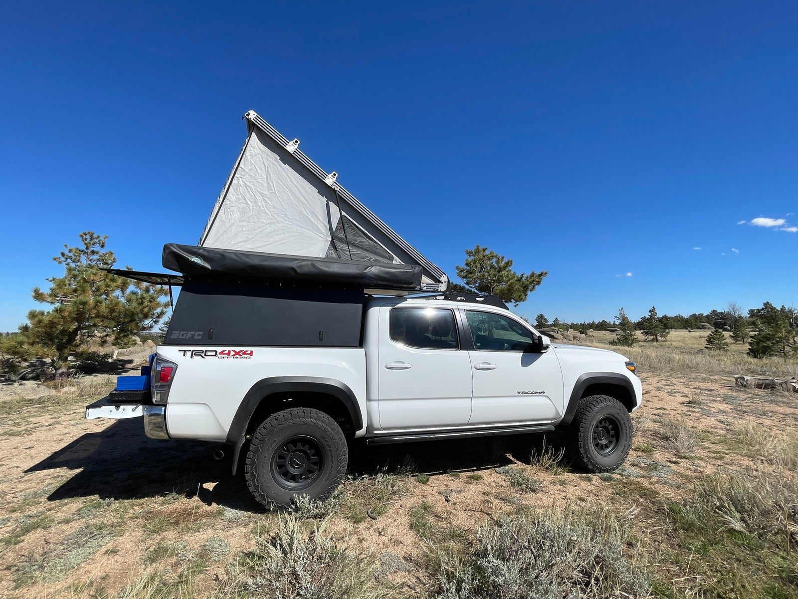 White Tacoma pickup with GFC rooftop tent & awning deployed. A versatile RV rental alternative for off-road camping.