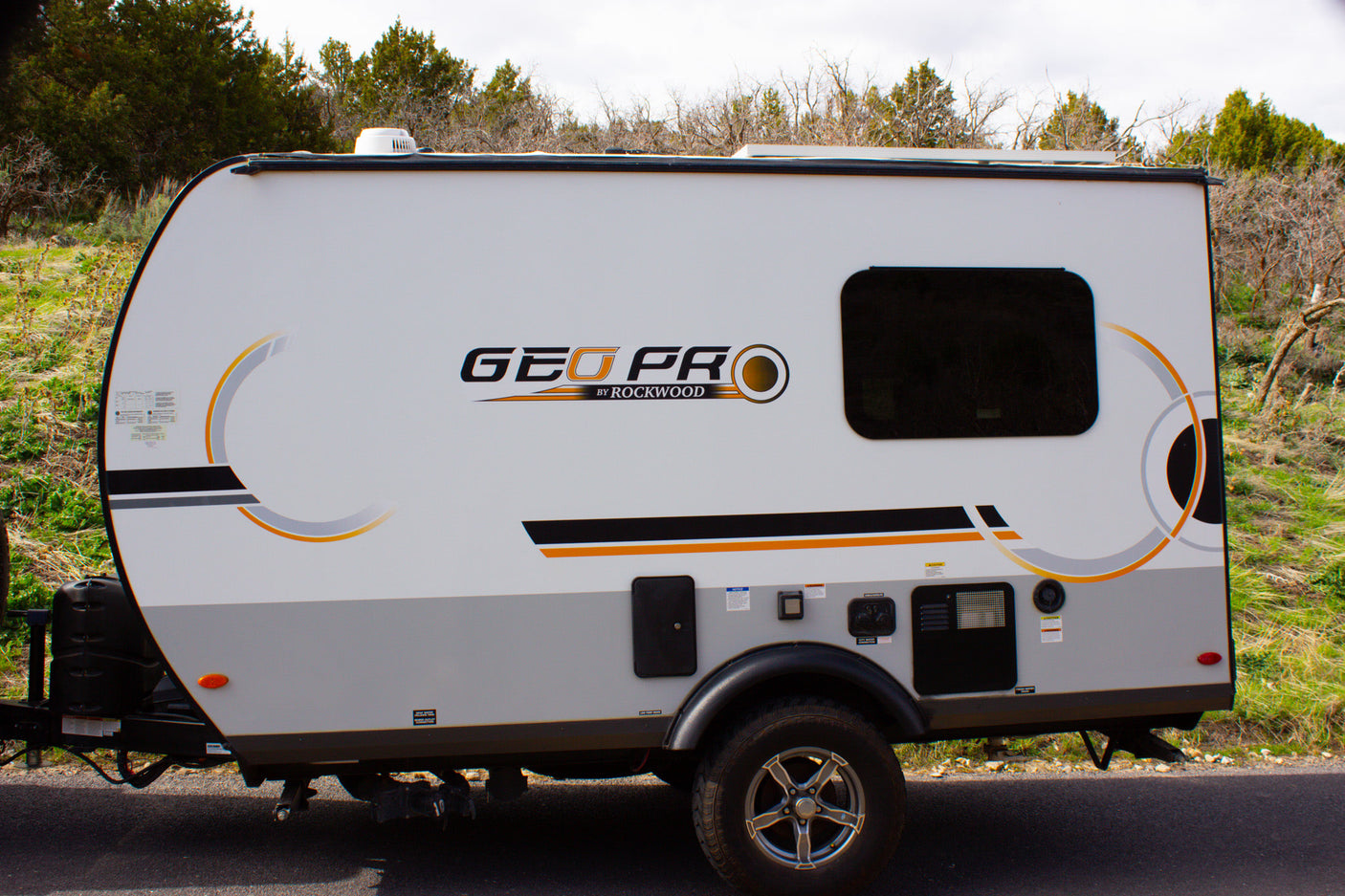 This compact white and grey GEO PRO travel trailer is ideal for an rv rental outdoor adventure.