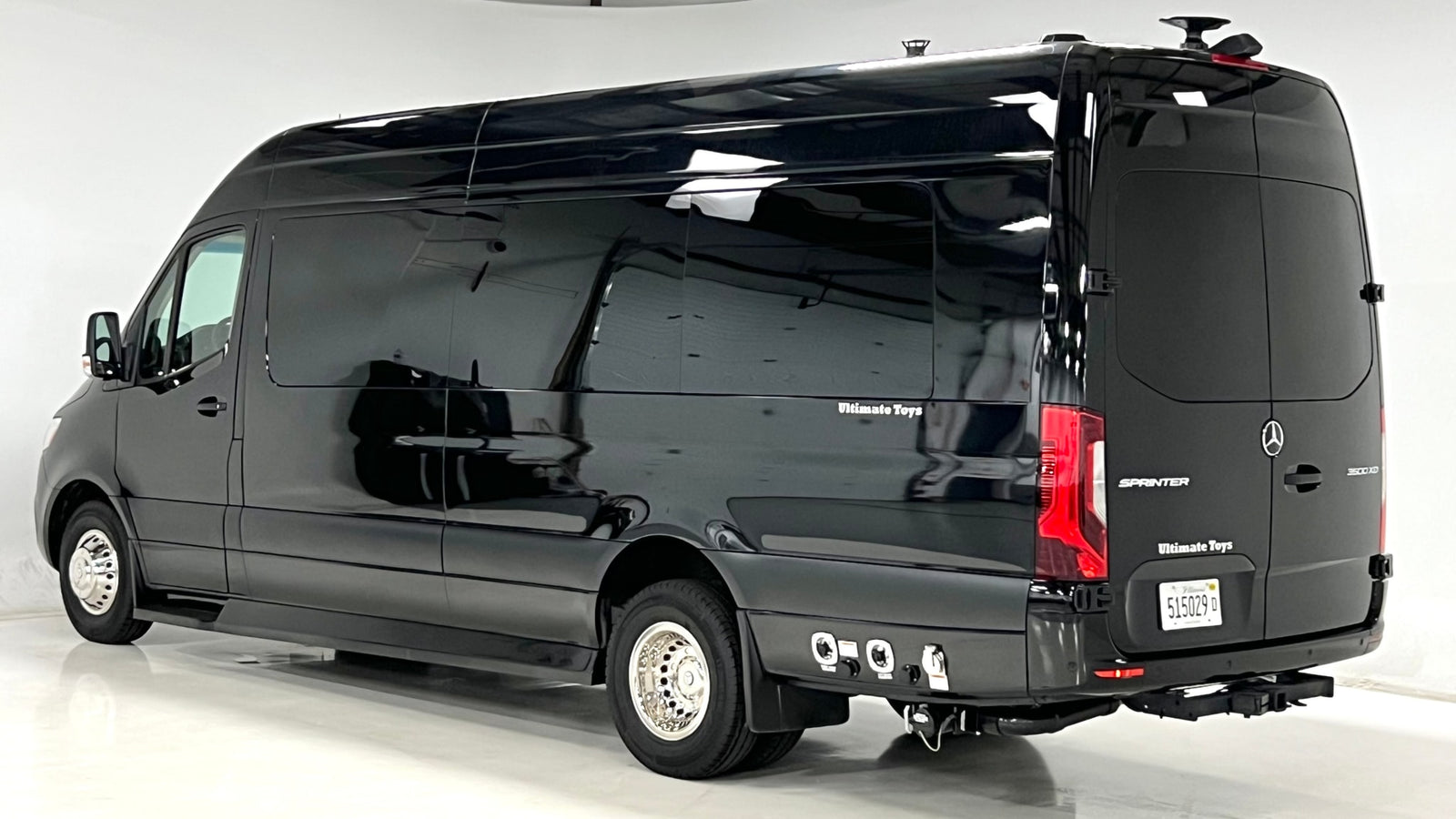 Black Mercedes Sprinter luxury RV rental by Ultimate Toys. Side view of sleek van with tinted windows & chrome wheels.