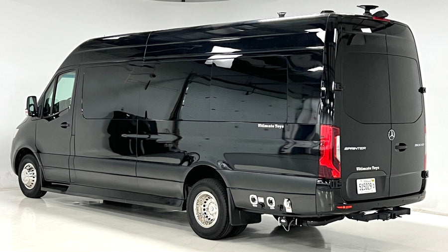 Black Mercedes Sprinter luxury RV rental by Ultimate Toys. Side view of sleek van with tinted windows & chrome wheels.
