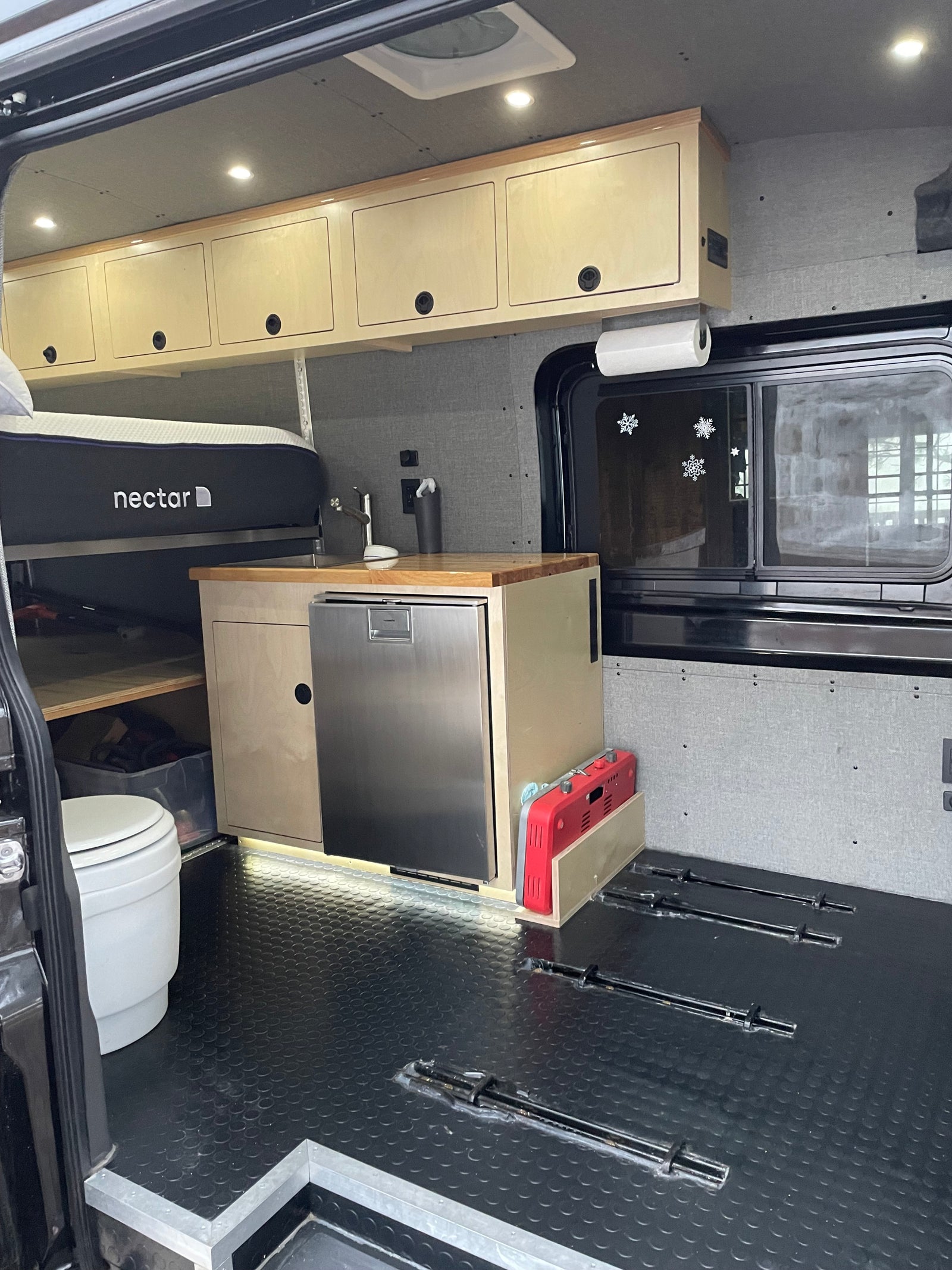 RV rental camper van interior featuring a Nectar bed, full kitchen with fridge, toilet, and ample storage for your journey.