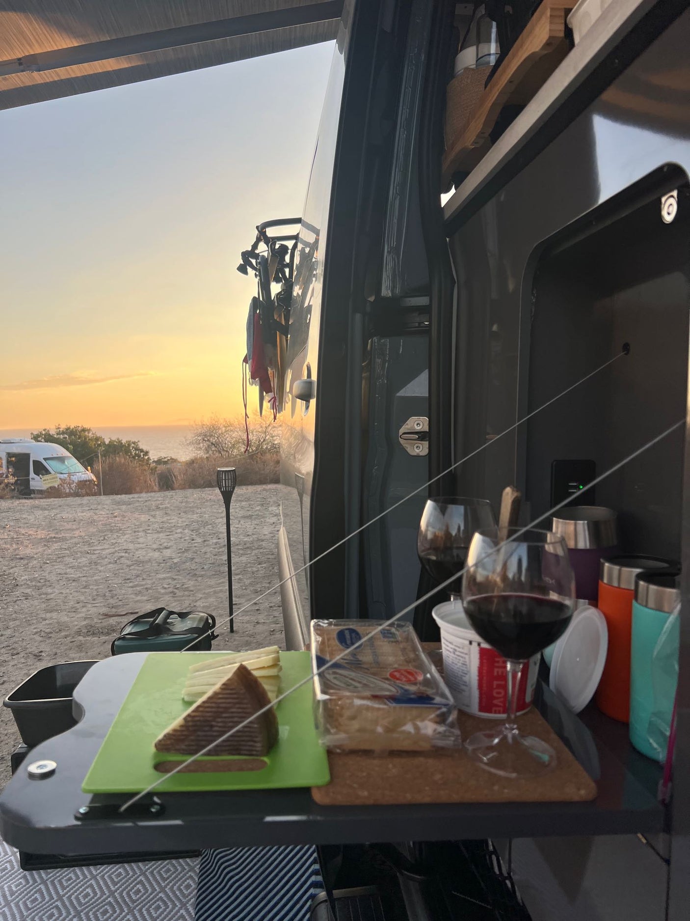 Scenic rv rental sunset: Wine, cheese, & ocean view from our van campsite. Perfect for a relaxing evening.