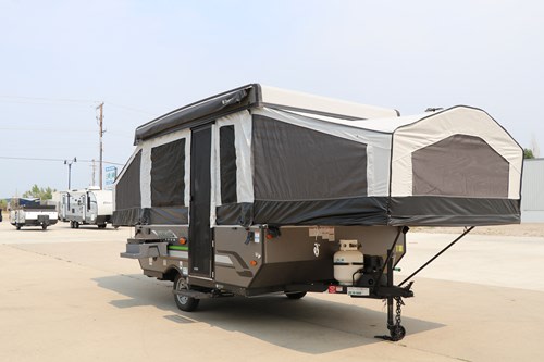 An RV rental pop-up camper is fully set up with its canvas walls and bed ends extended