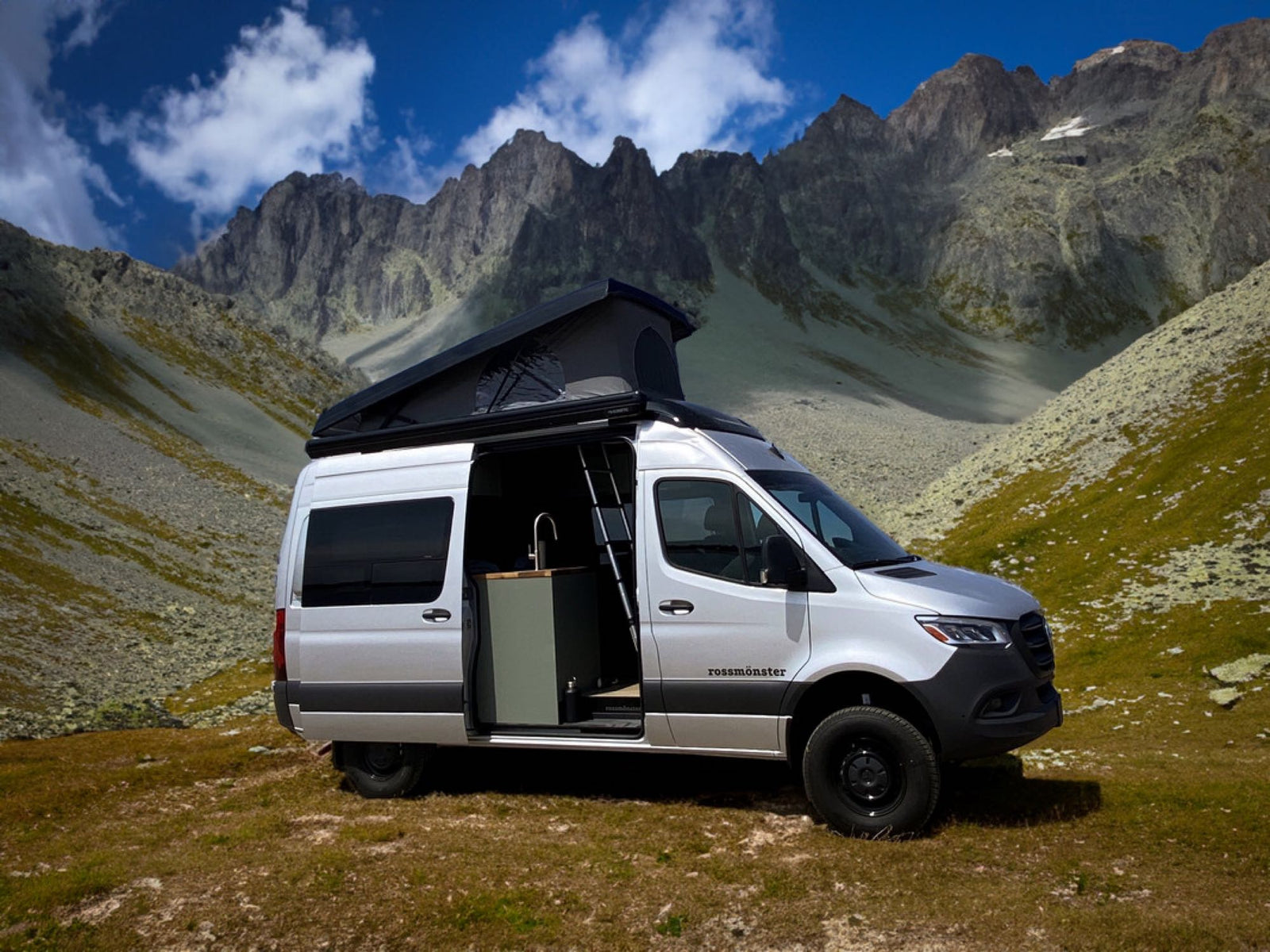 Adventure-ready Mercedes Sprinter camper van for RV rental, parked in a stunning mountain landscape with open pop-top.