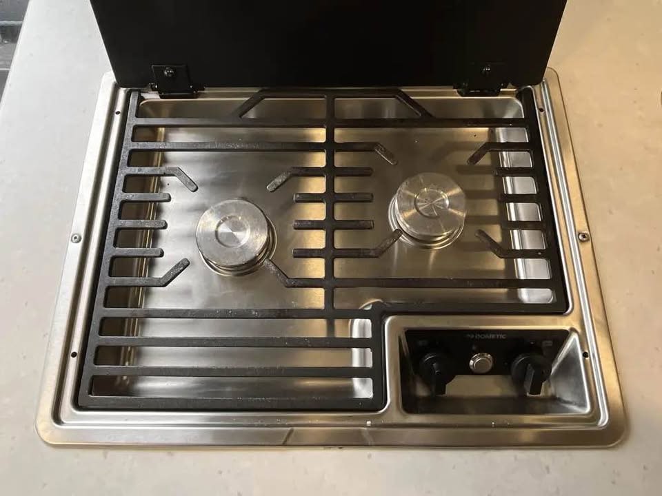 and floor storage drawers. Fire extinguisher visible.|This RV rental utility panel details propane controls (capped port