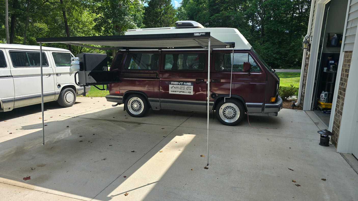 Maroon VW Westfalia camper van RV rental with deployed awning and rear grill. Ready for adventure!